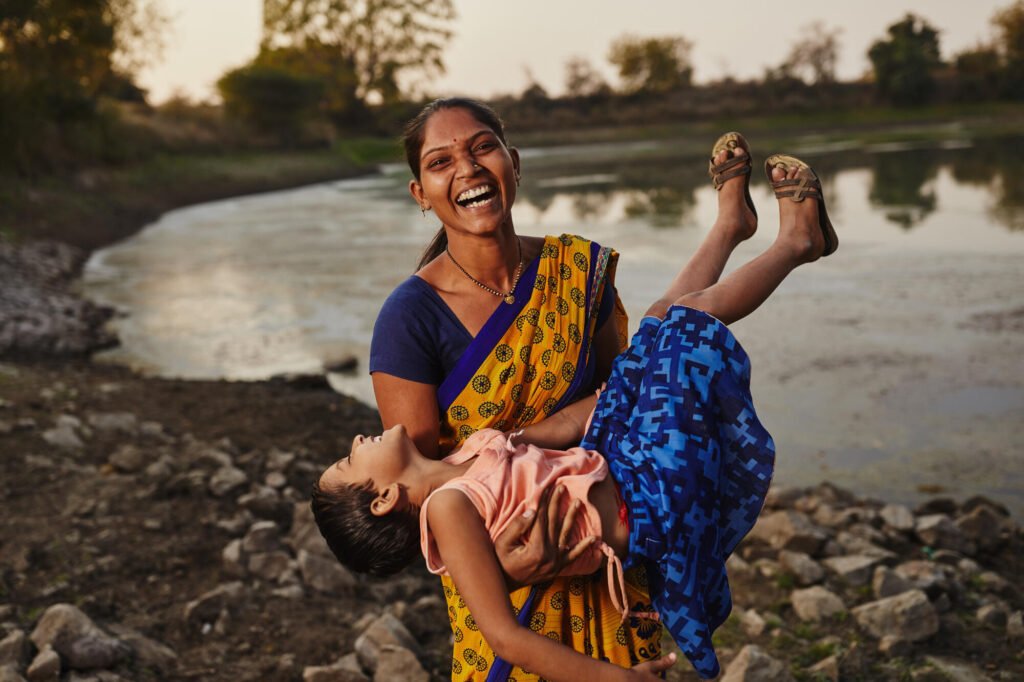 Intialainen äiti pitelee tytärtään sylissä.