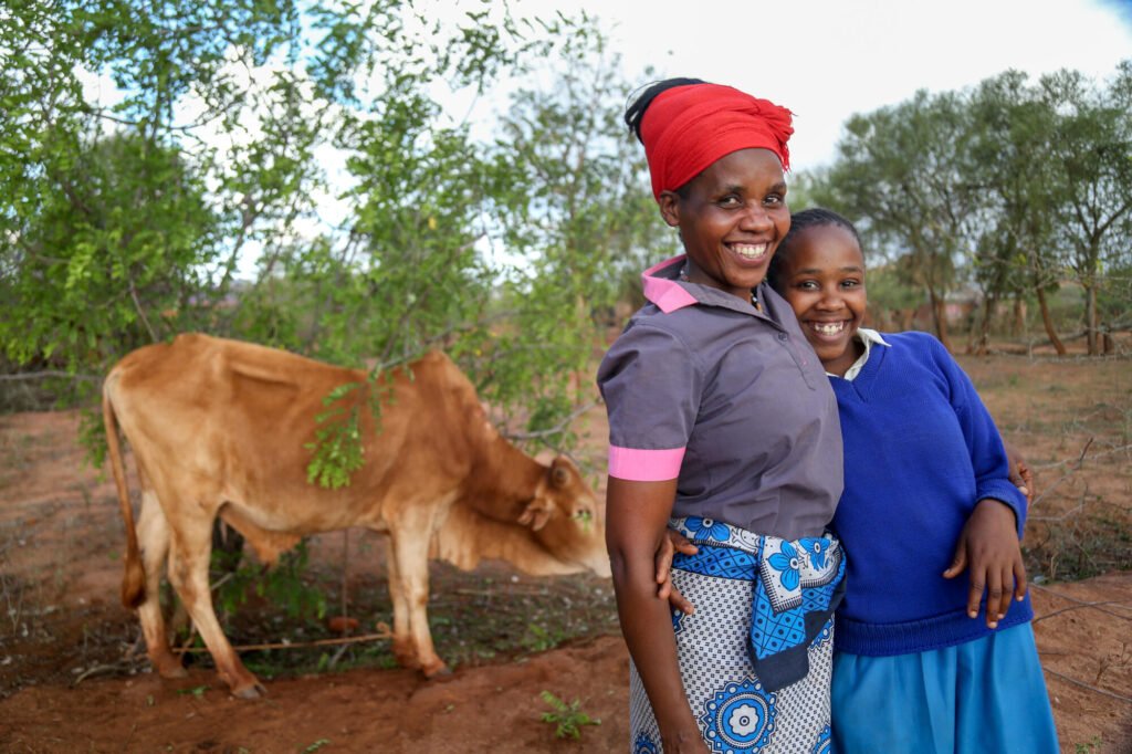 Kenialainen äiti ja tytär ja perheen lehmä.