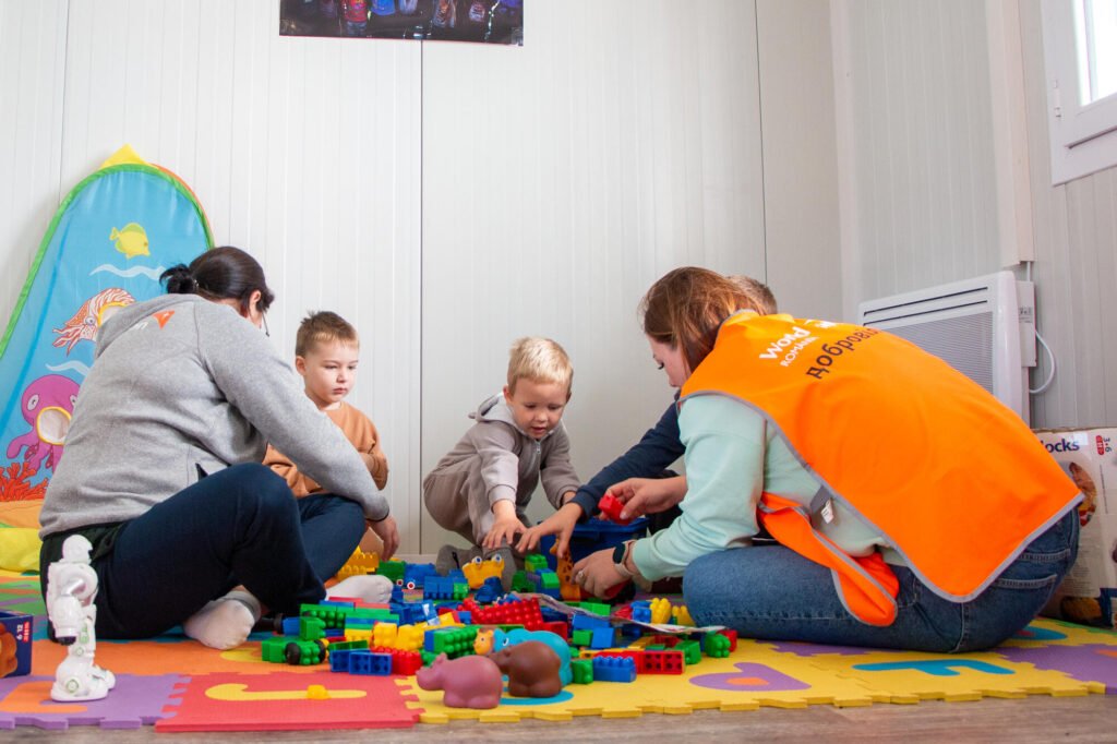 World Vision Romanian henkilökunta leikittämässä Ukrainalaisia lapsia lapsiystävällisessä tilassa.