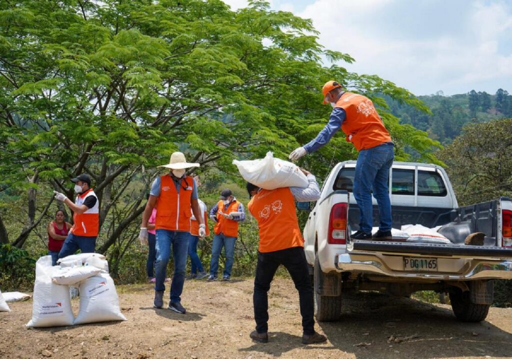 World Visionin paikalliset työntekijät purkaamassa ruokasäkkejä pakusta.