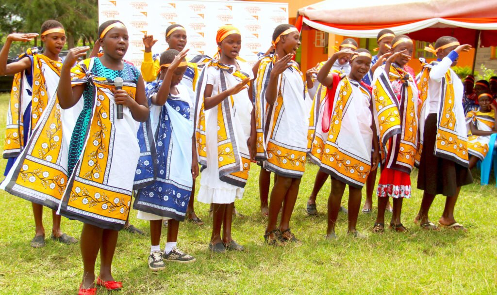 Kenialaisia teinityttöjä osallistumassa World Visionin järjestämään vaihtoehtoiseen aikuistumisjuhlaan. Tytöt ovat pukeutuneet hienosti ja esittävät laulu- ja tanssiesityksen.