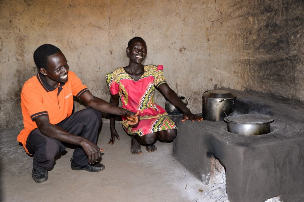 Ugandalainen nainen ja mies esittelemässä tehokasta keittoliettä.
